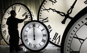 FILE - Electric Time Co. employee Walter Rodriguez cleans the face of an 84-inch Wegman clock at the plant in Medfield, Mass. Thursday, Oct. 30, 2008. (AP Photo/Elise Amendola, File)