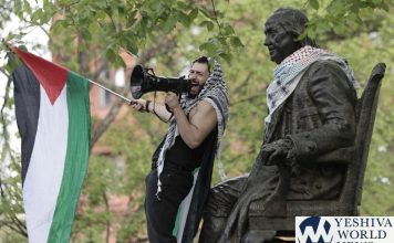 Qais Dana stands by the statue of Ben Franklin during a pro-Palestinian protest on College Green in the heart of the University of Pennsylvania campus in the in Philadelphia on Thursday, April 25, 2024.  (Elizabeth Robertson/The Philadelphia Inquirer via AP)