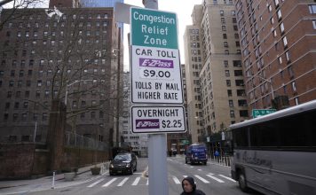 Signs advising drivers of congestion pricing tolls are displayed near the exit of the Lincoln Tunnel in New York, Wednesday, Feb. 19, 2025. (AP Photo/Seth Wenig)