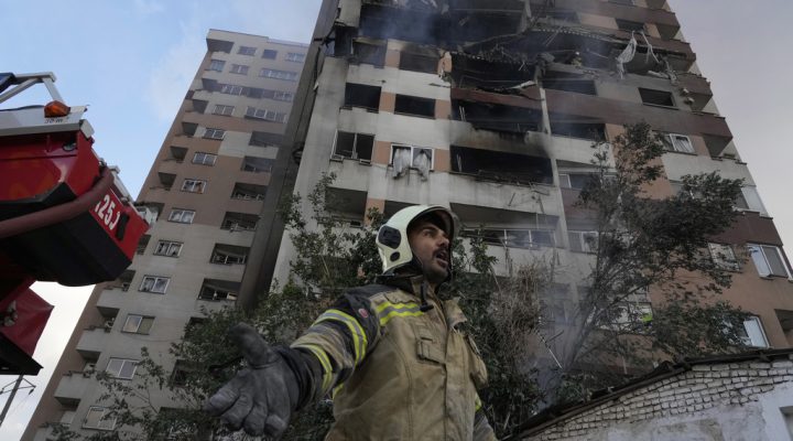 A firefighter calls out his colleagues at the scene of an explosion in a residence compound in northern Tehran, Iran, Friday, June 13, 2025. (AP Photo/Vahid Salemi)