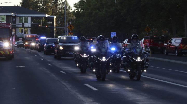 A procession from Kootenai Health headed to Spokane after a few firefighters were killed Sunday, June 29, 2025, when they were ambushed by sniper fire while responding to a blaze in a northern Idaho mountain community, in Coeur d’Alene, Idaho. (Bill Buley/Coeur D'Alene Press via AP)/