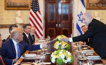 Israel's Prime Minister Benjamin Netanyahu, right, hands President Donald Trump a folder during a meeting in the Blue Room of the White House, Monday, July 7, 2025, in Washington. (AP Photo/Alex Brandon)